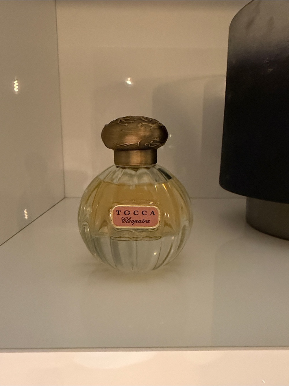 Tocca Perfume Bottle with Pink Accents and Amber Liquid